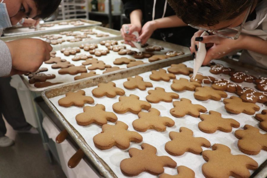 Students in Baking frosted about 80 gingerbread people to be sold on the cookie trays for the holiday. This piping technique is one that the students need to learn as it plays both parts for their learning and selling cookies.