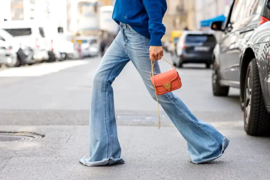 Model wearing flares while crossing the street.