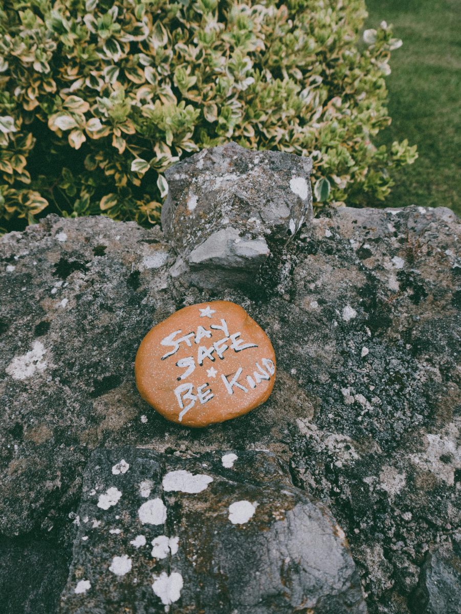 A painted rock encourages people to Stay Safe & Be Kind.